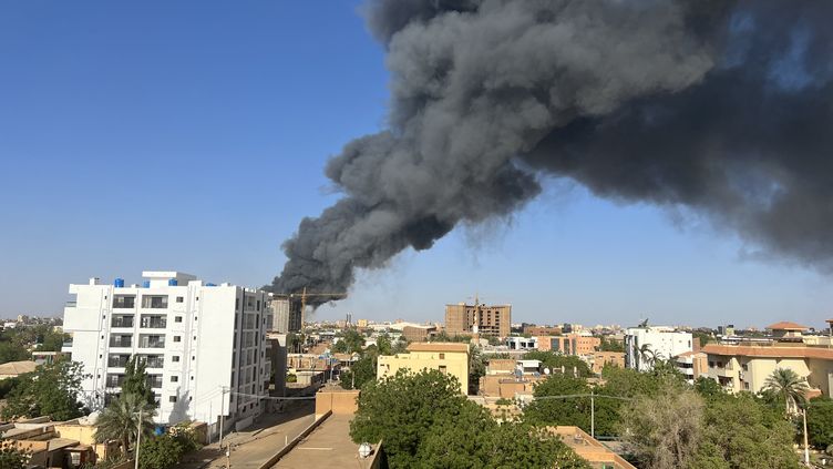 A column of smoke rises behind buildings near the airport in Khartoum, Sudan, on April 19, 2023. (AFP)