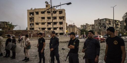 Cordon de policiers égyptiens autour d'un bâtiment de la sécurité nationale, dévasté par un attentat de Daech le 20 août 2015, dans le quartier de Choubra au Caire. (Khaled Desouki/AFP)