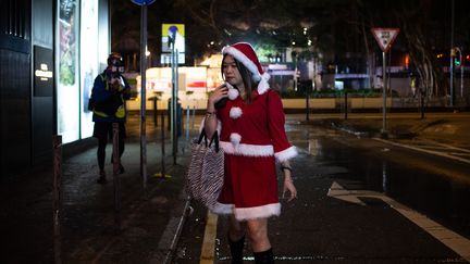 Est-ce une manifestante ou, plus probablement, une simple passante ? Cette&nbsp;femme déguisée a en tout cas été photographiée juste après que la police ait dispersé des manifestants au canon à eau, le 24 décembre&nbsp;à Hong-Kong, où la contestation du pouvoir chinois n'a pas connu de trêve des confiseurs. (PHILIP FONG / AFP)