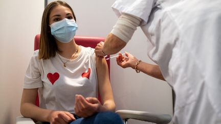 Une jeune femme reçoit une dose de vaccin contre le Covid-19 à Dinan (Côtes-d'Armor), le 30 avril 2021.&nbsp; (MARTIN BERTRAND / HANS LUCAS / AFP)