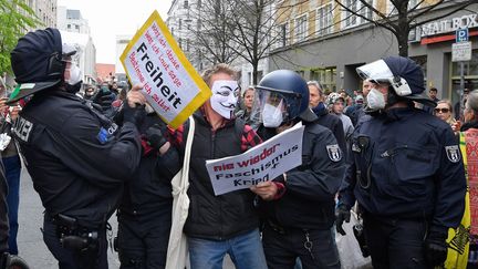 Des policiers arrêtent un manifestant contre les restrictions de circulation pour lutter contre l'épidémie de coronavirus, à Berlin le 25 avril 2020 (TOBIAS SCHWARZ / AFP)