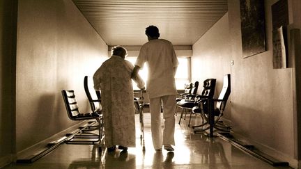 Un infirmier accompagne une personne &acirc;g&eacute;e dans le couloir de l'unit&eacute; de soins palliatifs de l'h&ocirc;pital de La Rochelle.&nbsp; (AUGE / SIPA)