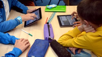 Des enfants travaillent avec des tablettes numériques (illustration). (DAMIEN MEYER / AFP)