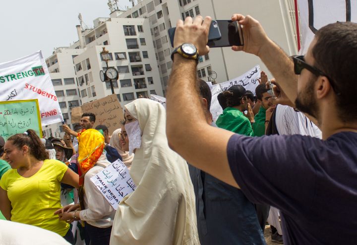 Le journaliste Mehdi Alioui avec ses deux smartphones, lors d'une manifestation des étudiants, le 27 juin 2019, à Alger. (CLEMENT PARROT / FRANCEINFO)