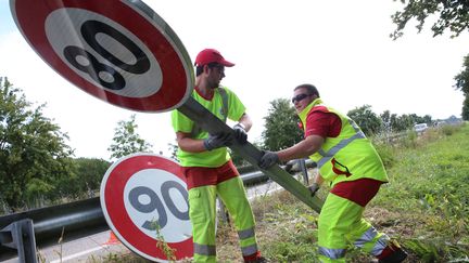 Des agents changent les panneaux de 90km/h en 80km/h en juin 2018.&nbsp; (HERVE KIELWASSER / MAXPPP)