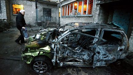 Un homme pr&egrave;s de sa voiture d&eacute;truite par un bombardement, dimanche 1er f&eacute;vrier 2015.&nbsp; (DOMINIQUE FAGET / AFP)