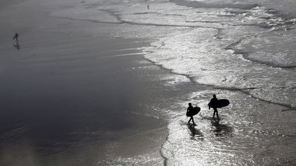 Des surfers à Biarritz, le 18 décembre 2015, où le thermomètre a indiqué 22°C.&nbsp; (REGIS DUVIGNAU / REUTERS)