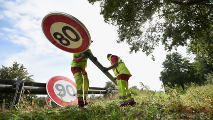 Des employés de la DIR replacent un panneau de limitation des 90 km/h à Wittenheim (Haut-Rhin), le 1er juillet 2018. (SEBASTIEN BOZON / AFP)