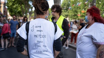 Une soignante dans une manifestation contre l'obligation vaccinale à Perpignan le 14 juillet 2021. (JEANNE MERCIER / HANS LUCAS)