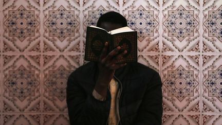 Une personne lit le Coran à la mosquée Ennour du Havre (Seine-Maritime), le 18 mai 2018. (CHARLY TRIBALLEAU / AFP)