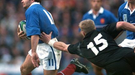 Christophe Dominici dans sa chevauchée fantastique lors de la Coupe du monde 1999 face aux All Blacks de Jeff Wilson (OLIVIER MORIN / FILES)