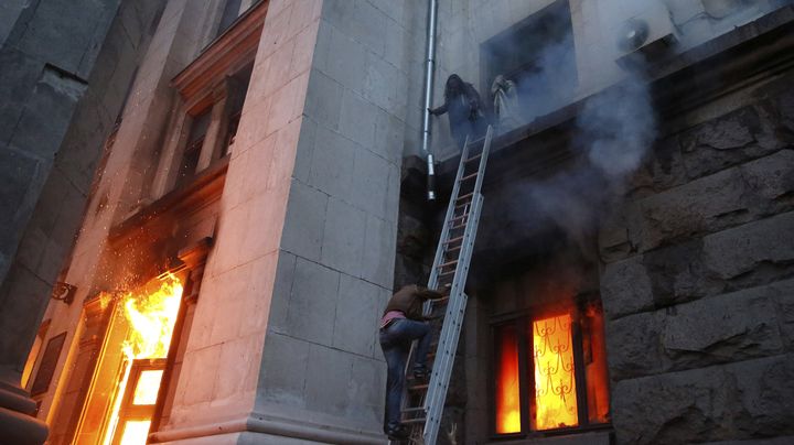 Prises au pi&egrave;ge, des personnes attendent d'&ecirc;tre secourues au second &eacute;tage de la Maison des syndicats en feu, vendredi 2 mai.&nbsp; (STRINGER / REUTERS)