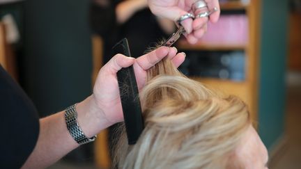 Une femme se faisant coiffer dans un salon. Photo illustrative. (LIONEL LE SAUX / MAXPPP)