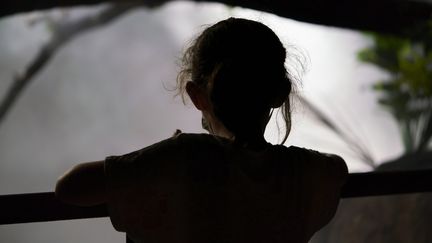 A young girl leans on a balcony. Illustrative image. (AREA IMAGES / MOMENT RF)