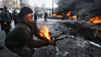 Un manifestant s'appr&ecirc;te &agrave; tirer un cocktail Molotov, le 23 janvier 2014. (SERGEI GRITS / AP / SIPA)