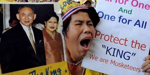 Une «chemise jaune», lors d'un blocage de l'aéroport international de Bangkok, le 2 décembre 2008. Elle brandit des pancartes favorables à la famille royale thaïlandaise. (AFP PHOTO/SAEED KHAN  )