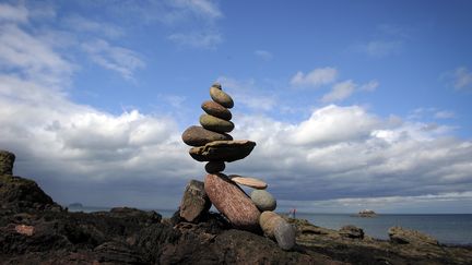 Un empilement de pierres (stone stacking) au bord de la mer. (ANDY BUCHANAN / AFP)