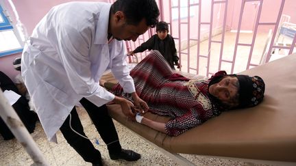 Un médecin examine une femme potentiellement atteinte du choléra, le 12 août 2017 à Sanaa (Yémen). (MOHAMMED HUWAIS / AFP)