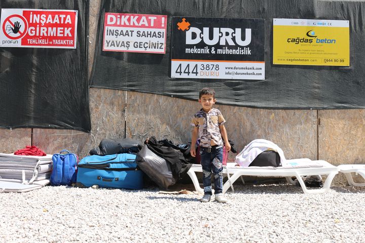 Un enfant syrien pose devant le campement de ses parents sur le front de mer de Bodrum (Turquie), le 21 ao&ucirc;t 2015. (BENOIT ZAGDOUN / FRANCETV INFO)