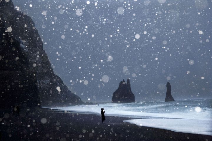 Une touriste sur une plage de sable noir et sous les flocons. (Géo  Christophe Jacrot)