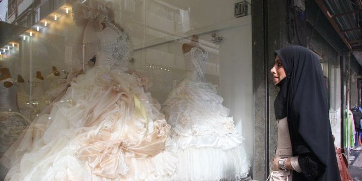 Une Iranienne devant une boutique de robes de mariées à Téhéran. (Atta Kenare / AFP)