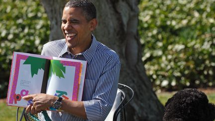 Le président américain Barrack Obama lit "Chicka Chicka Boom Boom' à côté du chien de la famille, Bo; pour la fête de pâques à la Maison Blanche, le 1er avril 2013.
 (MANDEL NGAN / AFP)