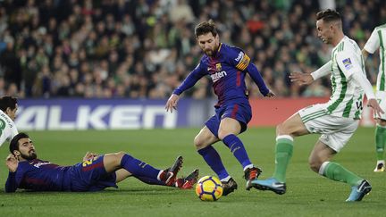 Lionel Messi au contact de la défense du Betis (CRISTINA QUICLER / AFP)