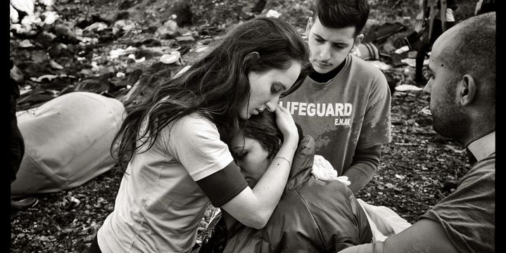 Lesbos, Grèce. Une jeune volontaire grecque du corps des sauveteurs en mer réconforte une réfugiée irakienne. Enceinte et en état de choc après la traversée en bateau depuis la Turquie, celle-ci a fait un malaise à son arrivée sur la plage.
 (Marie Dorigny / MYOP pour le Parlement européen 2016.)