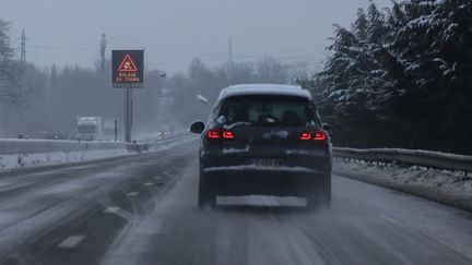 Une voiture roule sur une route enneigée à Vimy (Pas-de-Calais), le 9 janvier 2025. (DENIS CHARLET / AFP)