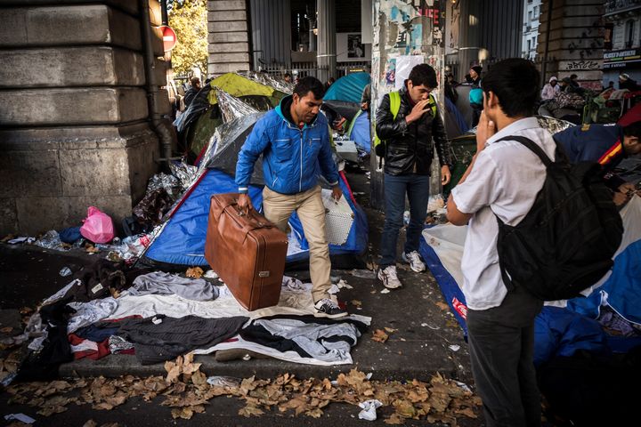 Un homme quitte la camp de migrants de Stalingrad avec sa valise, lundi 31 octobre 2016 à Paris. (LIONEL BONAVENTURE / AFP)