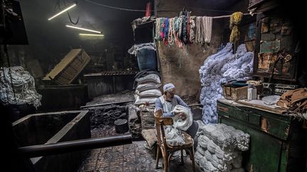 A 83 ans, Salama Mahmoud Salama est le propriétaire depuis 1974 d'une des plus célèbres teintureries artisanales du Caire. Chaque matin, il commence son travail en préparant les pelotes de fils à teindre.&nbsp; &nbsp; &nbsp; (KHALED DESOUKI / AFP)