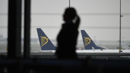 Une membre d'une compagnie aérienne face à des avions de Ryanair au sol, à l'aéroport de Charleroi (Belgique), le 28 septembre 2018. (JOHN THYS / AFP)