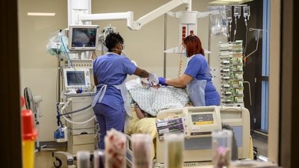 Des soignantes s'occupent d'un patient atteint de Covid-19 à l'hôpital Avicennes de Bobigny (Seine-Saint-Denis), en février 2021. (BERTRAND GUAY / AFP)