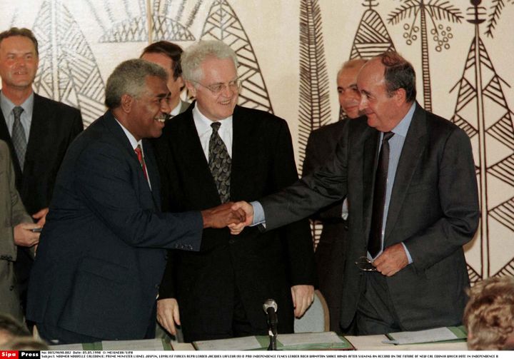 Le Premier ministre, Lionel Jospin (c), observe une poignée de mains entre l'indépendantiste Roch Wamytan (g) et le non-indépendantiste Jacques Lafleur (d), le 5 juin 1998, après la signature d'un accord à Nouméa (Nouvelle-Calédonie). (MEIGNEUX/SIPA)