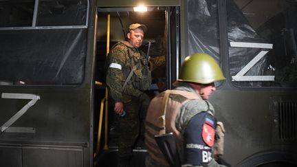 Des membres de la République populaire du Donetsk accompagnent un bus de soldats ukrainiens blessés de Marioupol vers une partie du territoire ukrainien contrôlée par Moscou, le 16 mai 2022. (ALEXEY KUDENKO / SPUTNIK / AFP)