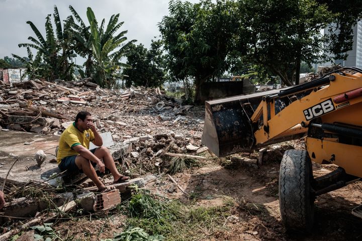 Un Brésilien assis devant les ruines de sa maison, démolie pour laisser place aux infrastructures&nbsp;des Jeux olympiques, le 8 mars 2016. (YASUYOSHI CHIBA / AFP)