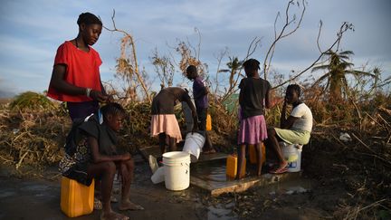 Des Haïtiens pompent de l'eau à une citerne dans le sud-ouest de l'île le 11 octobre 2016 (HECTOR RETAMAL / AFP)