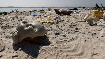 Une t&ecirc;te de poup&eacute;e retrouv&eacute;e sur une plage de la baie de Guanabara, pr&egrave;s de Rio (Br&eacute;sil), le 30 juillet. (SERGIO MORAES / REUTERS )