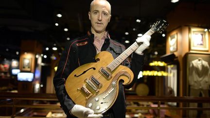 Martin Nolan, le directeur de la maison de ventes new-yorkaise Julien's Auctions, tient une guitare des Beatles. Elle a été vendue pour 408.000 dollars
 (Timothy Clary / AFP)