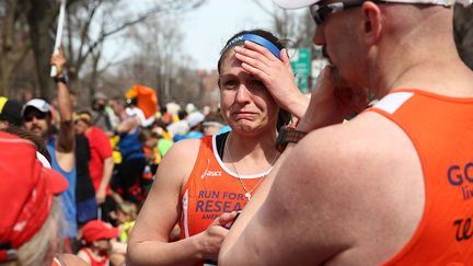 Des coureurs sous le choc apr&egrave;s les explosions qui ont fait au moins deux morts pendant le marathon de Boston, lundi 15 avril. (ALEX TRAUTWIG / GETTY IMAGES NORTH AMERICA)