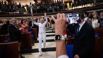 Sous les applaudissements de représentants de tout le continent, la flamme traverse l'hémicycle du Conseil de l'Europe, à Strasbourg, le 26 juin 2024. (SEBASTIEN BOZON / AFP)