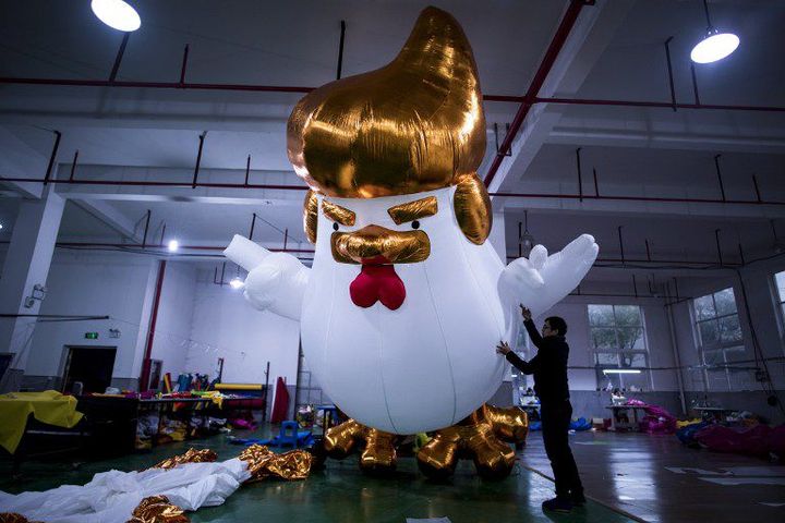 Des ouvriers installent une sculpture gonflable d'un gallinacée à l'effigie de Donald Trump à Jiaxing (province de Zhejiang, est de la Chine) le 6 janvier 2017. (AFP - JOHANNES EISELE)