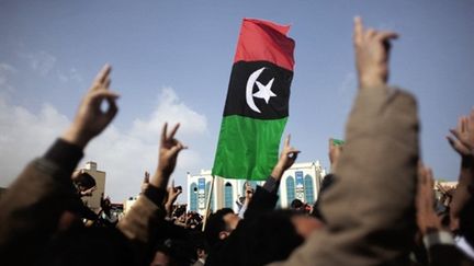 L'ancien drapeau lybien brandi comme symbole contre le régime de Mouammar Kadhafi (25/02/2011) (AFP/MARCO LONGARI)