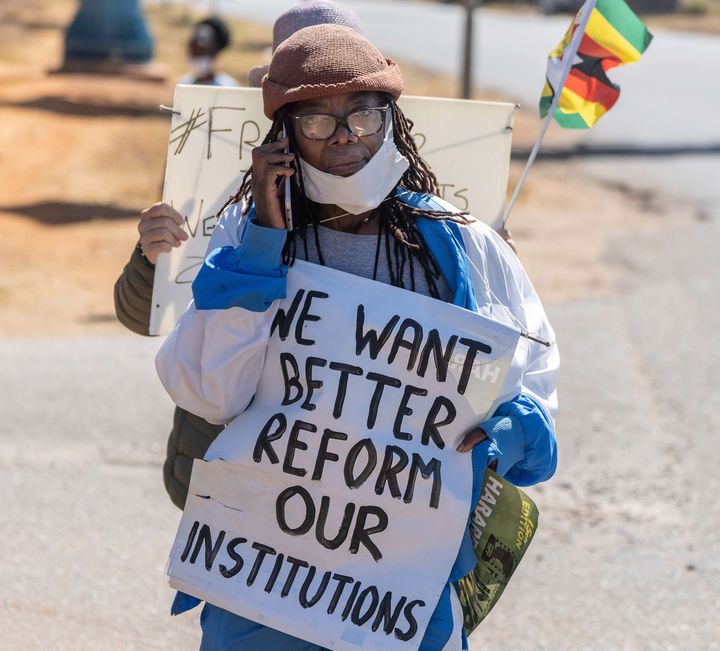 L'écrivaine zimbabwéenne&nbsp;Tsitsi Dangarembga le 31 juillet 2020 à Harare, à la manifestation durant laquelle elle a été arrêtée. Sur la pancarte qu'elle tient, on peut lire : "Nous voulons une meilleure réforme" et "nos institutions". (ZINYANGE AUNTONY / AFP)