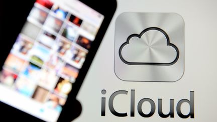 Un smartphone tenu près du logo de service de Cloud d'Apple iCloud, lancé le 3 septembre 2014. (DANIEL REINHARDT / DPA)