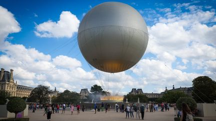 Au fil de leur parcours le long de la Seine, les 2 jeunes visiteurs lyonnais, Émilien et Antonin, se sont approchés de la vasque de la flamme olympique. (VIRGINIE LEFOUR / MAXPPP)