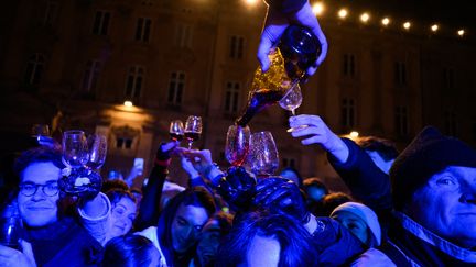 Le traditionnel débouchage des premiers tonneaux de Beaujolais nouveau à Lyon, le 21 novembre 2024, à 00h01. (JEAN-PHILIPPE KSIAZEK / AFP)