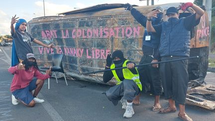 Des jeunes sur un barrage à Nouméa ont inscrit sur la carcasse d'un véhicule "Abat la colonisation, vive la kanaky libre". (ERIC AUDRA / FRANCEINFO)