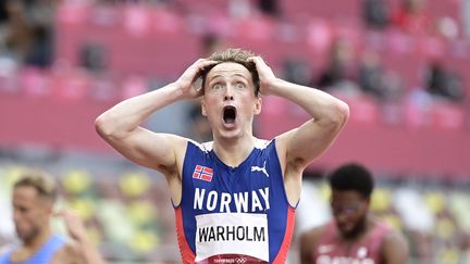 Karsten Warholm en mode Le cri d'Edvard Munch au moment où il réalise qu'il vient d'exploser le record du monde du 400 mètres haies en finale des Jeux olympiques de Tokyo le 3 août 2021. (JAVIER SORIANO / AFP)