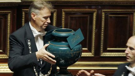 Des huissiers se passent une urne, au S&eacute;nat, &agrave; Paris, le 22 octobre 2010. (JACQUES DEMARTHON / AFP)